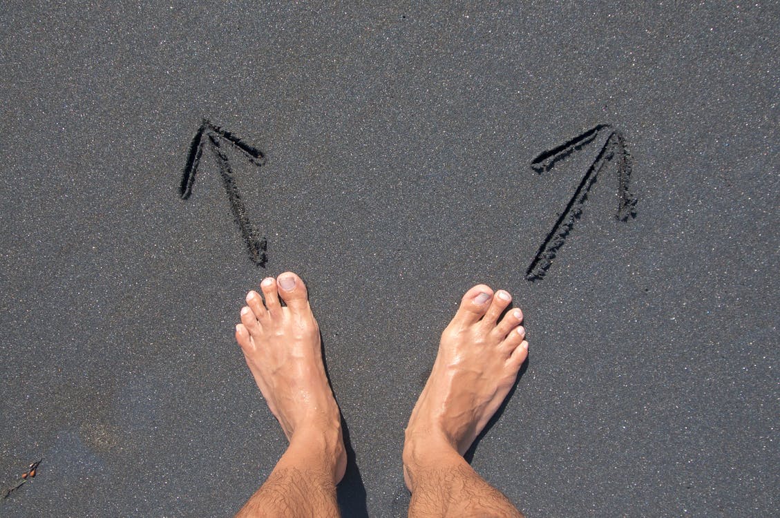 Person Standing Barefoot on Black Sand Beach