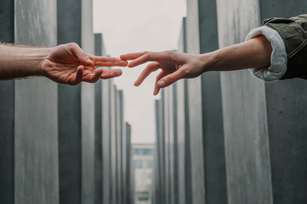 two person touching each others finger tips