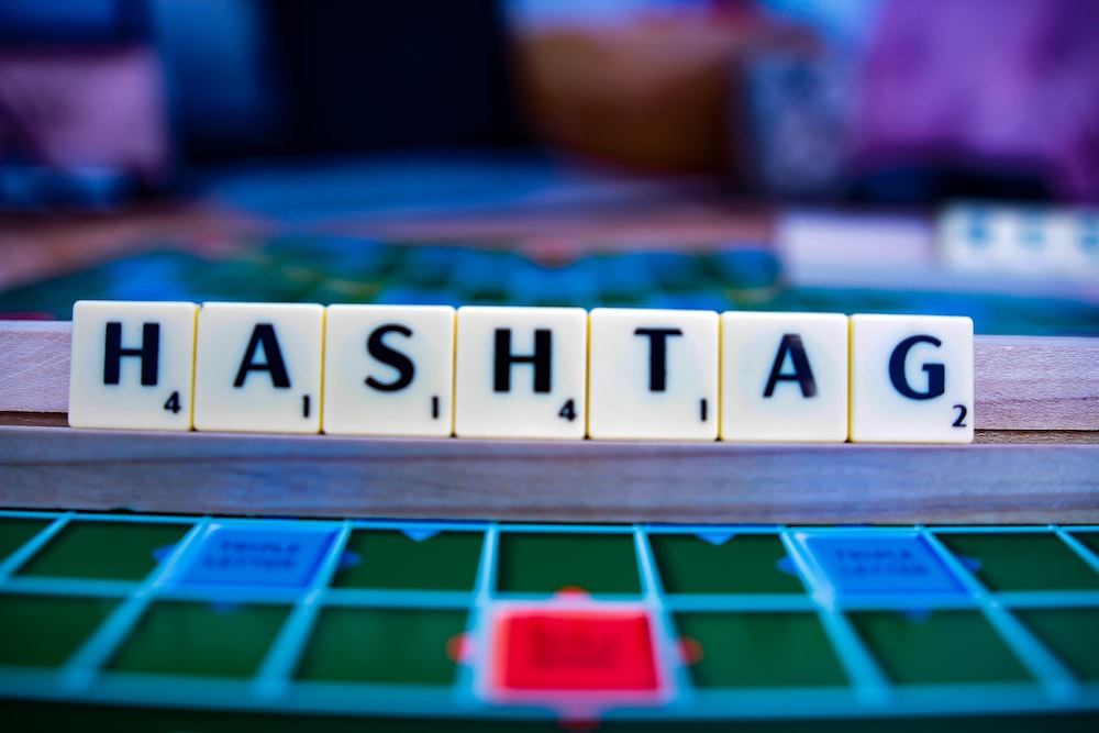 scrabble tiles spelling hashtags on a board game