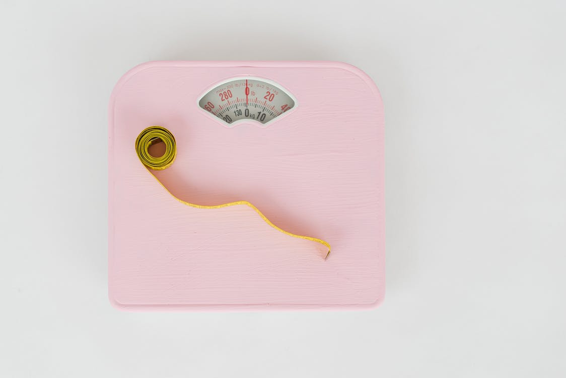 Scales and measuring tape on white floor